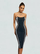 Black dress with silver embellishments on a plain background